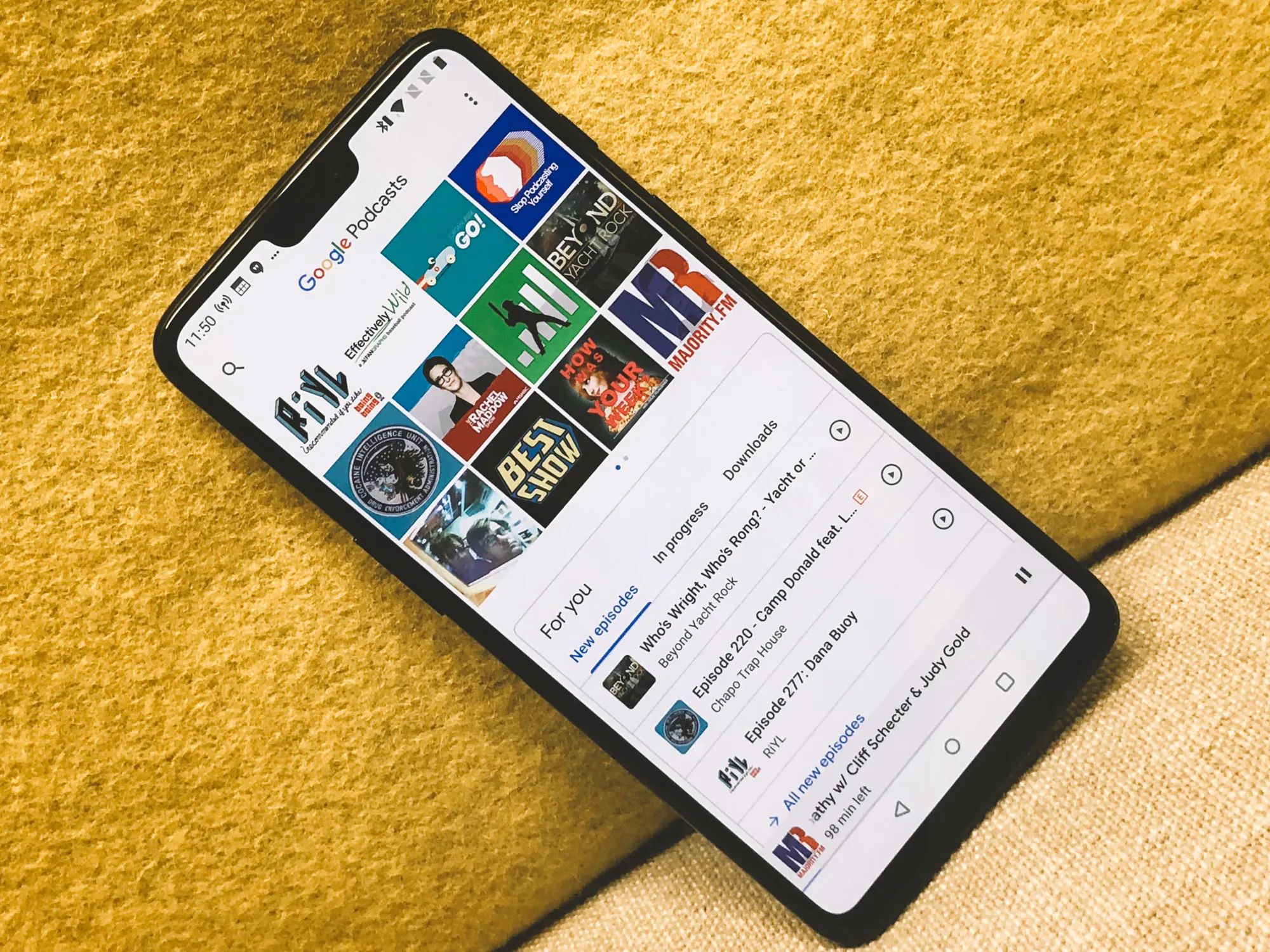 Pixel phone showing the Google Podcasts app on a yellow textured surface